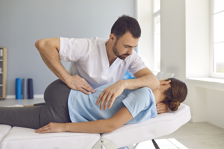 Male Norwest chiropractor fixing a woman's back